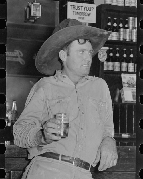 Trust You? Tomorrow, Maybe!’ Cowboy drinking beer in beer parlor, Alpine, Texas. Russell Lee, May 19