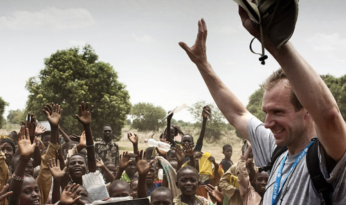 Ralph Fiennes donando ayuda a algunos niños de África