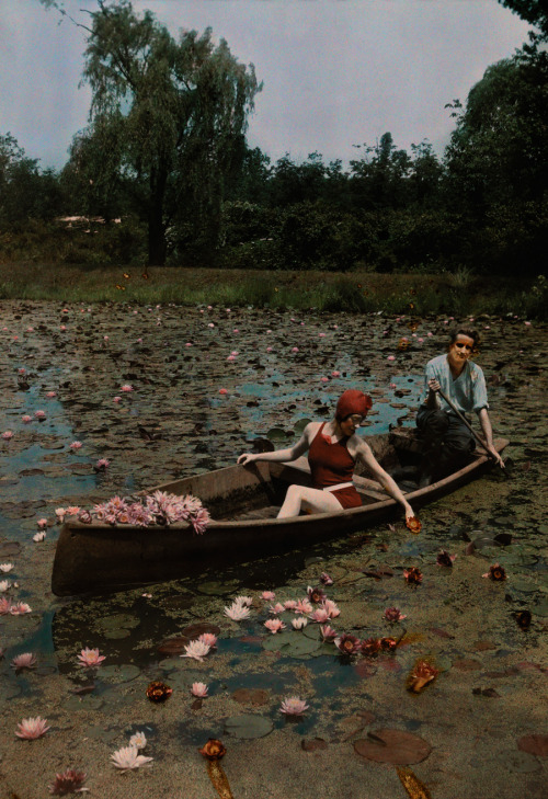 A couple in a boat paddle on a lily pond and collect flowers in the Kenilworth Aquatic Gardens in Wa