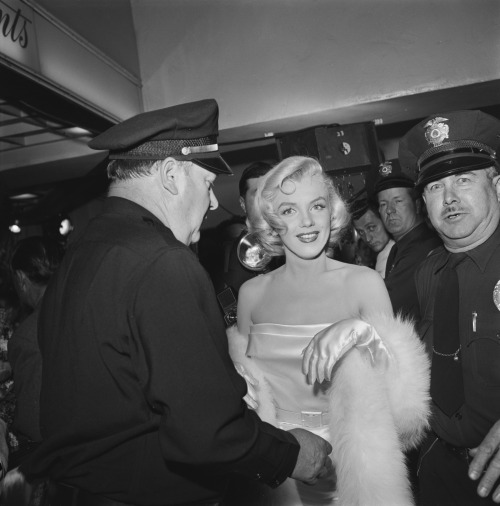 Marilyn Monroe surrounded by police officers at the premiere of Call Me Madam in Los Angeles, Califo