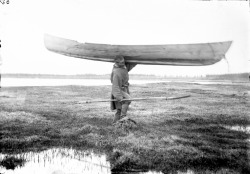 Yakut fisherman carrying canoe, Siberia