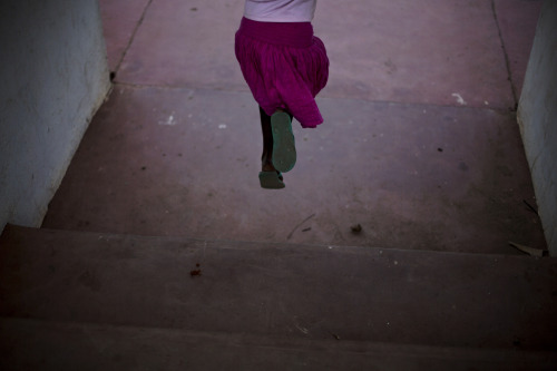 A young girl jump over a couple of steps at Juba Basketball Stadium, South Sudan  © Camill