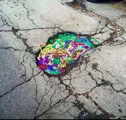 atomic-nein:mardi gras bead filled pothole in New Orleans