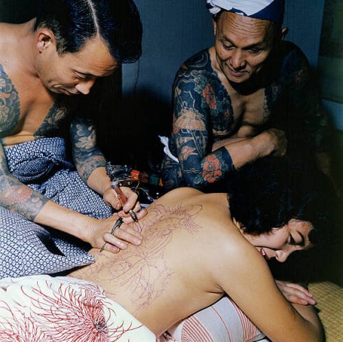 s-h-o-w-a:Japanese tattoo artist Tokumitsu Uchida works over outline of design with needle-pointed e