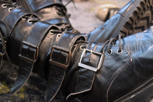 describedgoth:[ID: A close up photo of a person’s black leather boot, their boots have at least four