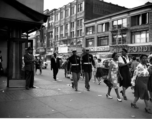 Two marines walking down a street in Harlem, New York, 1943. Photograph by Roger Smith.