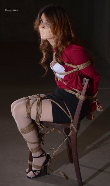 God, what a fucking perfect damsel in distress she is. Her outfit, the way she’s securely tied to a chair in the middle of an empty lit basement, the way she’s staring at her captor because the tape tightly plastered across her face has silenced her