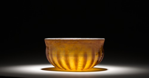 ancientpeoples:Ribbed Glass BowlRoman1st Century A.D.This type of vessel represents a Roman manufacturing breakthrough that made high-quality glassware broadly affordable for the first time. The ribs were pressed into a heated glass disk with a tool,