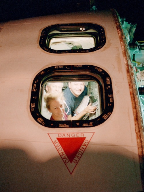 fuckyeahfemaleastronauts:  Marsha Ivins, Kenneth Cockrell and Mark Polansky seen through a window of Atlantis. (x)