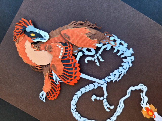 catadromously:curlicuecal:Halloween papercraft of this gorgeous artwork by @catadromously. I love the idea of chickens holding a seance and accidentally summoning their dinosaur ancestor.Have to confess, I got an hour into those little feather and bone