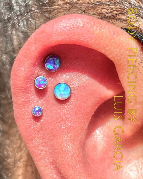 Added this fresh flat piercing with an @anatometalinc light blue opal to accent this triple helix th