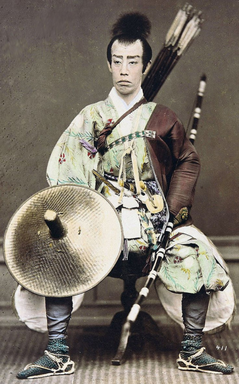 Samurai holding a yumi (bow) and wearing a yugote (shooting sleeves) over his left arm.  Hand-colore