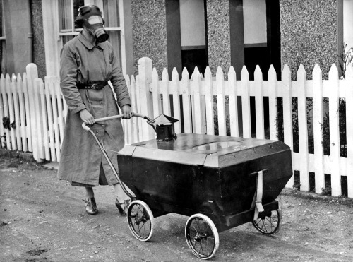 Une femme avec une poussette équipée d'un système anti-gaz. Angleterre, 1938.Un habitant de Hextable, dans le Kent, a inventé un landau étanche aux gaz dans lequel un bébé peut être gardé en sécurité pendant un raid aérien. Le landau est doté