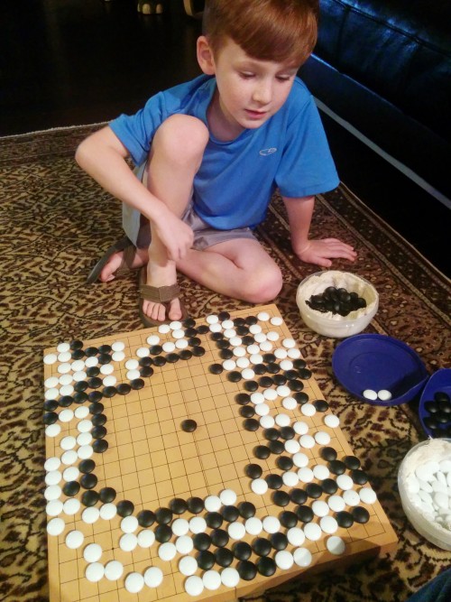 dadhowto:   If you know how to play Weiqi / Igo / Baduk already, or are interested in it, your kid can be a good player with you. I started teaching Kid the very small basics at age 3, mostly the capture game, first capture wins. He’s 6 years old as