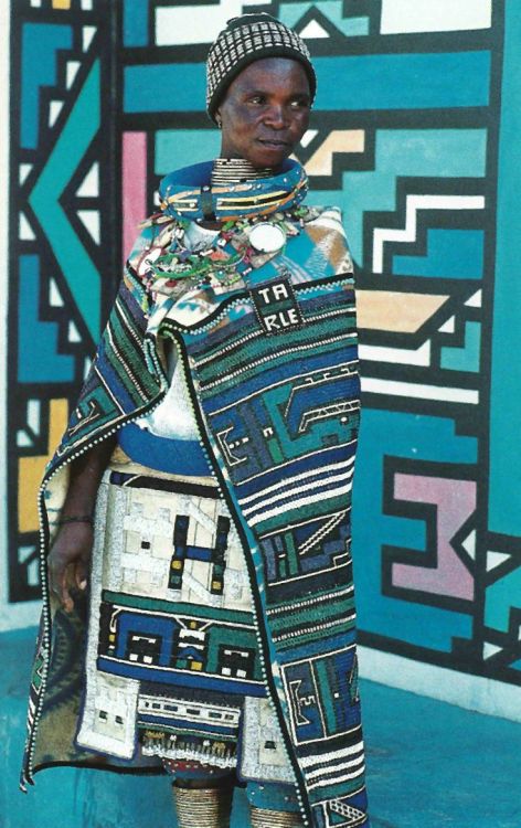 jamesusilljournal:Ndebelewoman standing in front of a traditionally painted Ndebele home, South Afri