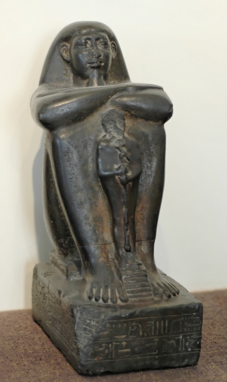 Ancient Egyptian block-statue of a ship-master named Pa-Ankh-Ra, who is shown with a statue of the g