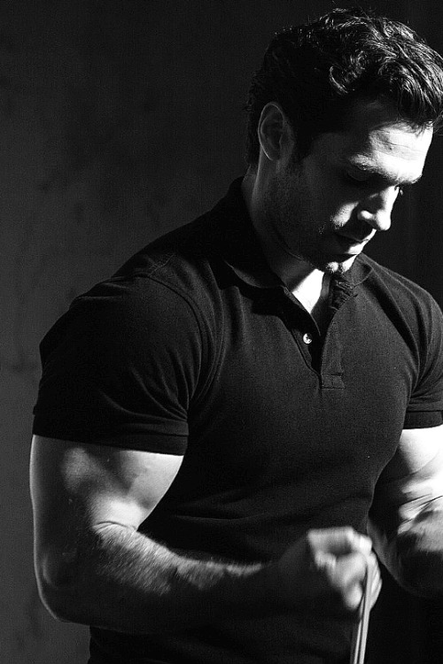 Henry Cavill gets pumped for a photoshootCavill with intense concentration uses exercise bands to pu