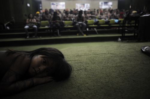 A child from the Munduruku tribe rests in the auditorium of the Brazil’s Indian affairs bureau (FUNAI) headquarters while Munduruku Indians occupy the building in Brasilia on June 10, 2013. The Indians from the Amazon Basin are demonstrating against...