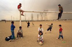 ouilavie:A. Abbas. Iran. Tehran. 1998. Kids play football in the suburbs of the capital, next to electricity pylons.