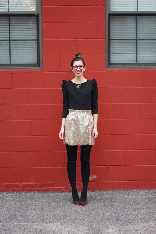 Black opaque tights, gold skirt and black blouse with tartan heels