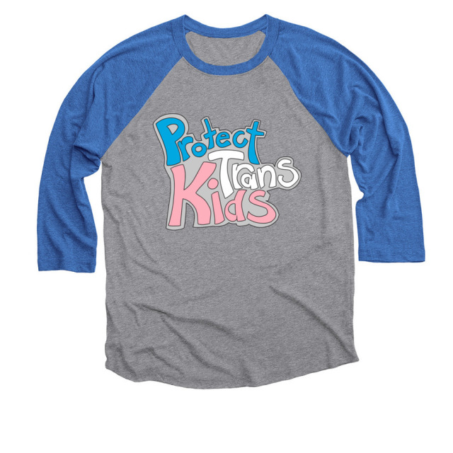 A grey t-shirt with blue sleeves. There is a design on the chest that reads "Protect Trans Kids," eaxh word in blue, white, and pink respectively.