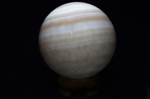 A moon?  A planet?  No, it’s a 4-inch orange calcite sphere, pictured under short wave ultraviolet, 