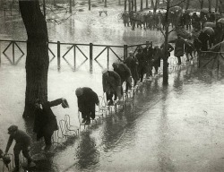 historicaltimes:  People walk across a row of chairs to avoid flood waters in Paris, 1924 