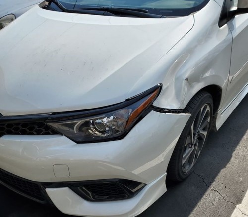 (image description: a photo of a white car with a heavily dented front side/bumper.)hello, friends. 