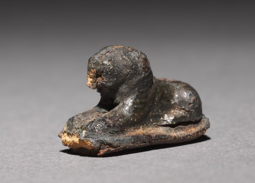 Ancient Egyptian bead (silver foil over a clay-bulked resin core) in the shape of a recumbent lion.&