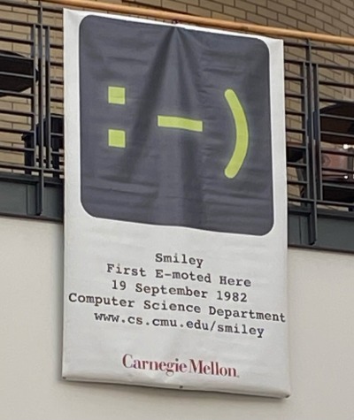 weaver-z:blackcvrrant:blackcvrrant:blackcvrrant:SOMETIME IN THE LAST WEEK MY SCHOOL PUT UP A LARGE BANNER DEDICATED TO THE :-) EMOTICON[id: a banner with a huge image of the :-) (smiley face with nose) emoticon captioned “smiley / first emoted here