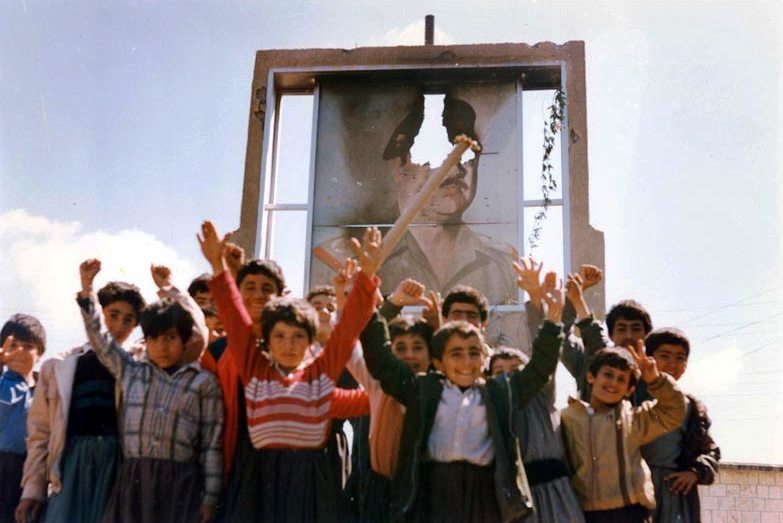 kchikurdi:children of halabja stand before defaced portrait of saddam hussein. 1988