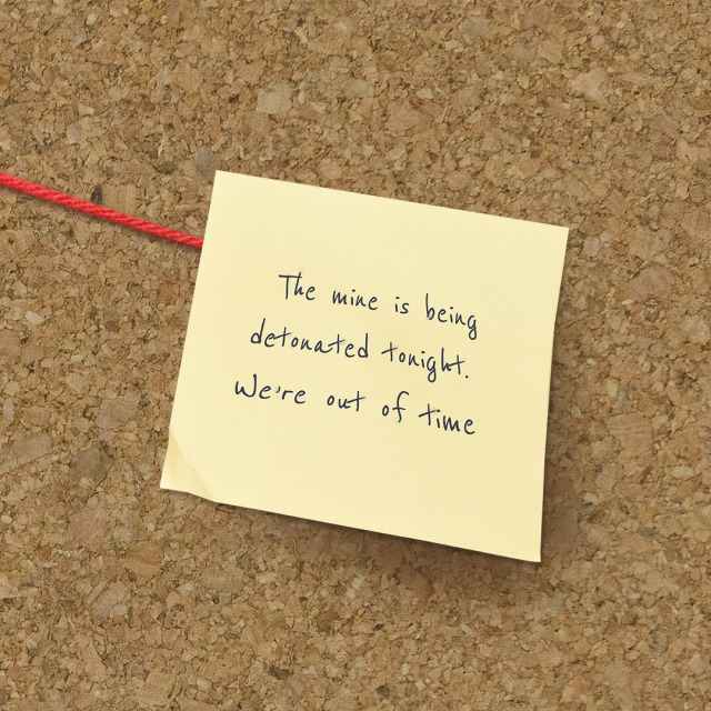 a post it note on a cork board that reads in Ross' handwriting "The mine is being detonated tonight. We're out of time."