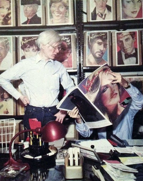 Andy Warhol at the factory looking over the latest cover by Richard Bernstein