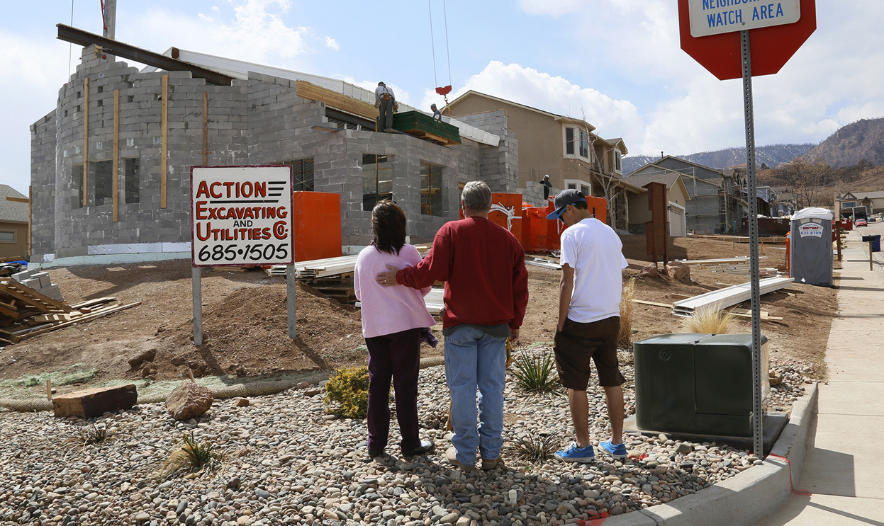 From Rebuilding After the Waldo Canyon Fire, one of 19photos. Members of the Howell family look at their house under construction in the aftermath of the Waldo Canyon fire that destroyed most of the homes on this road, including Howell’s, in Colorado...