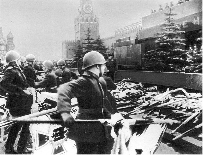 historicaltimes:  Soviet Soldiers toss the banners of the defeated Third Reich onto