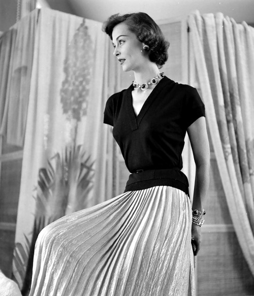 Model wearing gold lamè skirt and black jersey sweater photographed by Nina Leen, 1950