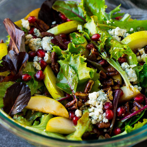 This pear salad recipe is mixed greens with fresh sliced pears, pomegranate seeds, blue cheese and c