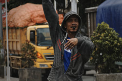 Solicitors helping cars on a U-turn for petty cash. Bandung, Indonesia