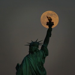 newyorkcityfeelings:  Moonrise over the Statue of Liberty by @GaryHershorn