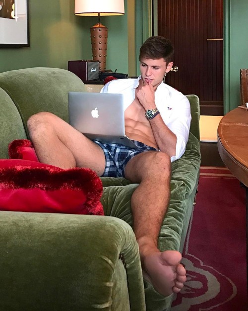 Dude with serious abs… searching the web on his couch barefoot with no pants