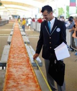 holy sweet shit :o  The world&rsquo;s longest pizza was created in Milan over the weekend! It took 18 hours, 1.5 tons of mozzarella, 2 tons of tomato sauce and more than 60 chefs to make it. It&rsquo;s 1.59545 kilometres (nearly a mile) long.and fed 30k