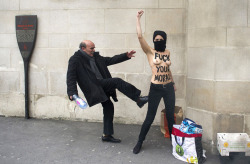 politics-war:  A man kicks a topless Femen