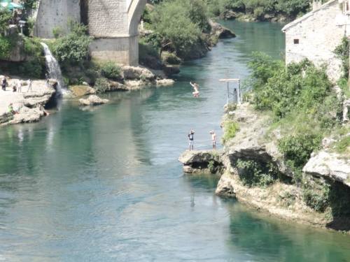 A girl is jumping into the Neretva River at Mostar