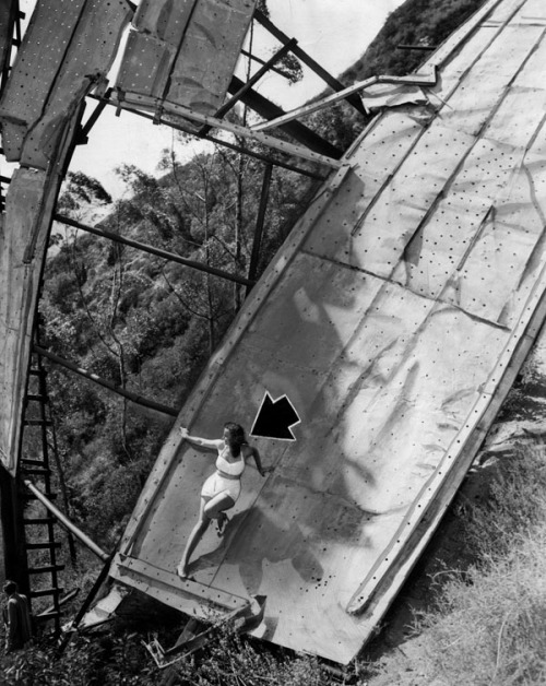 A model poses on the huge fallen “H” of the Hollywood sign in this newspaper photo from 1947. The letter collapsed after being struck by a drunk driver who drove off the peak of Mt. Lee in the early 1940’s. The sign was finally repaired in 1949.