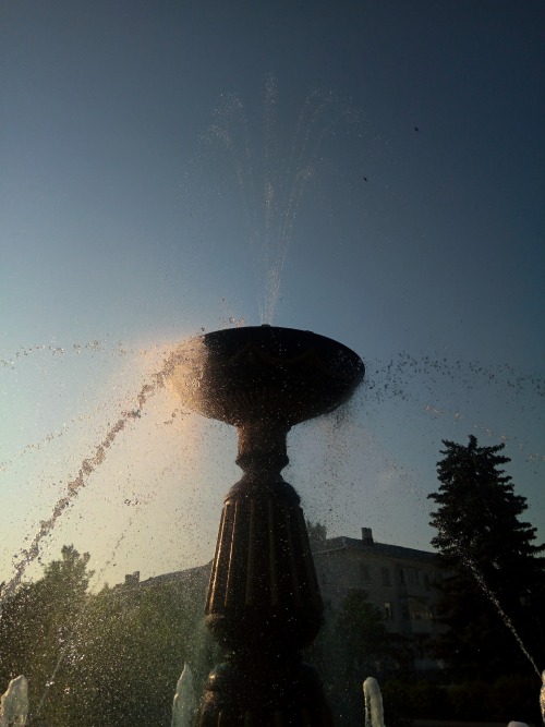.City Fountain In The Rays Of The Setting Sun.