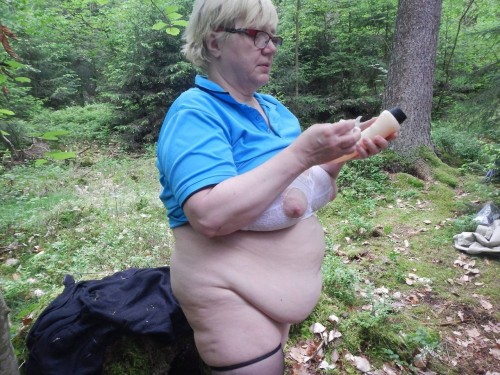 Porn photo This flabby granny is undressing in the woods.