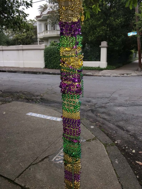 This corner stop sign has been bedazzled with reused Mardi Gras beads!