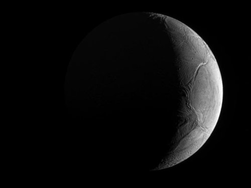 Crescent EnceladusPeering from the shadows, the Saturn-facing hemisphere of tantalizing inner moon E