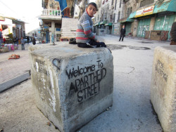 redsoulja:  The street on the right was once the main shopping district in Hebron. In 1994, the Israeli occupying forces forced the closure of some 500 Palestinian shops and barred Palestinians from driving there. By 2000, they had barred Palestinian