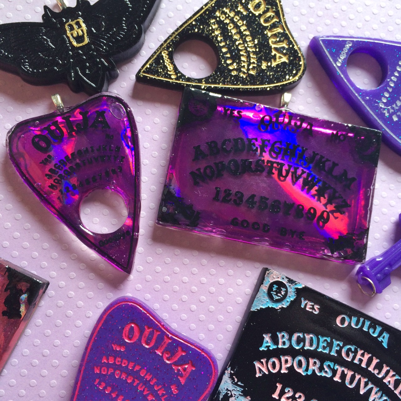 jinxandcurses:  NEW! Holographic ouija boards in planchettes in pink, purple, blue,